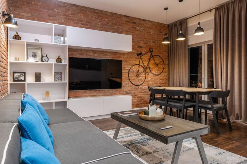 Salon style industriel avec mur en brique apparente et mobilier métal-bois
